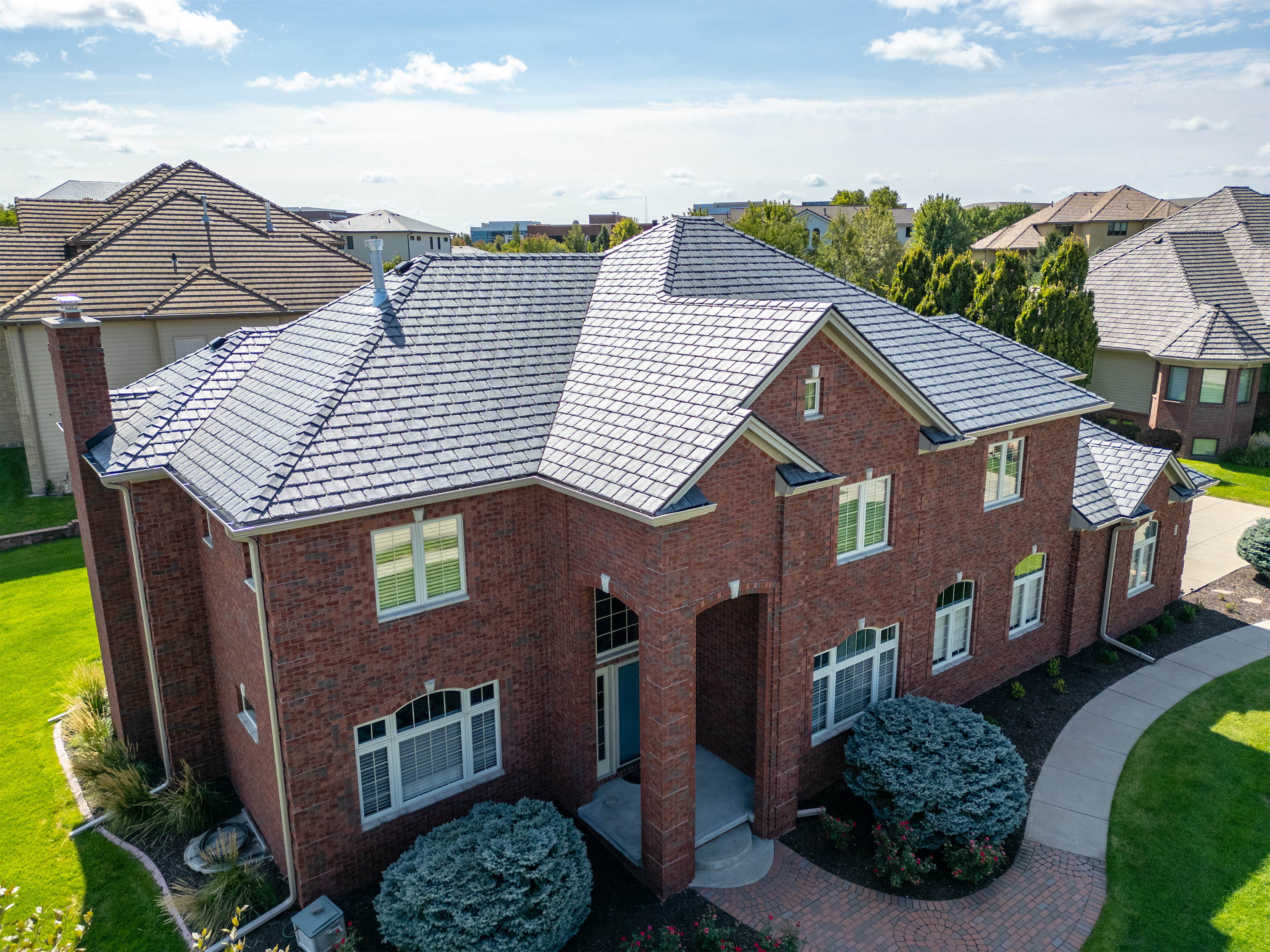 Roof Rite workers installing a Davinci Composite Shake roof in Weathered Gray on an affluent, colonial style, brick house.