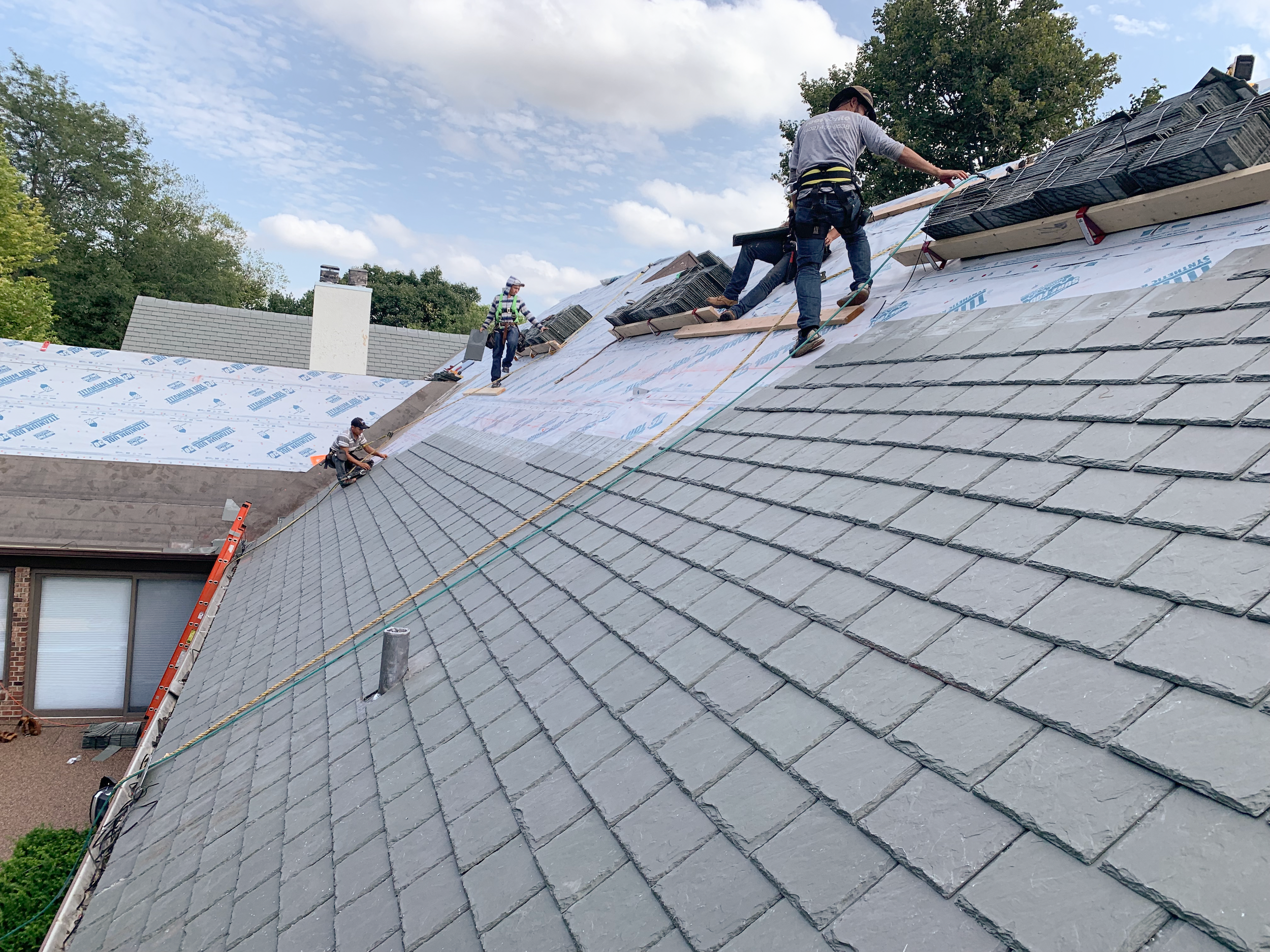 Roof Rite workers installing a Davinci Composite Shake roof in Weathered Gray on an affluent, colonial style, brick house.
