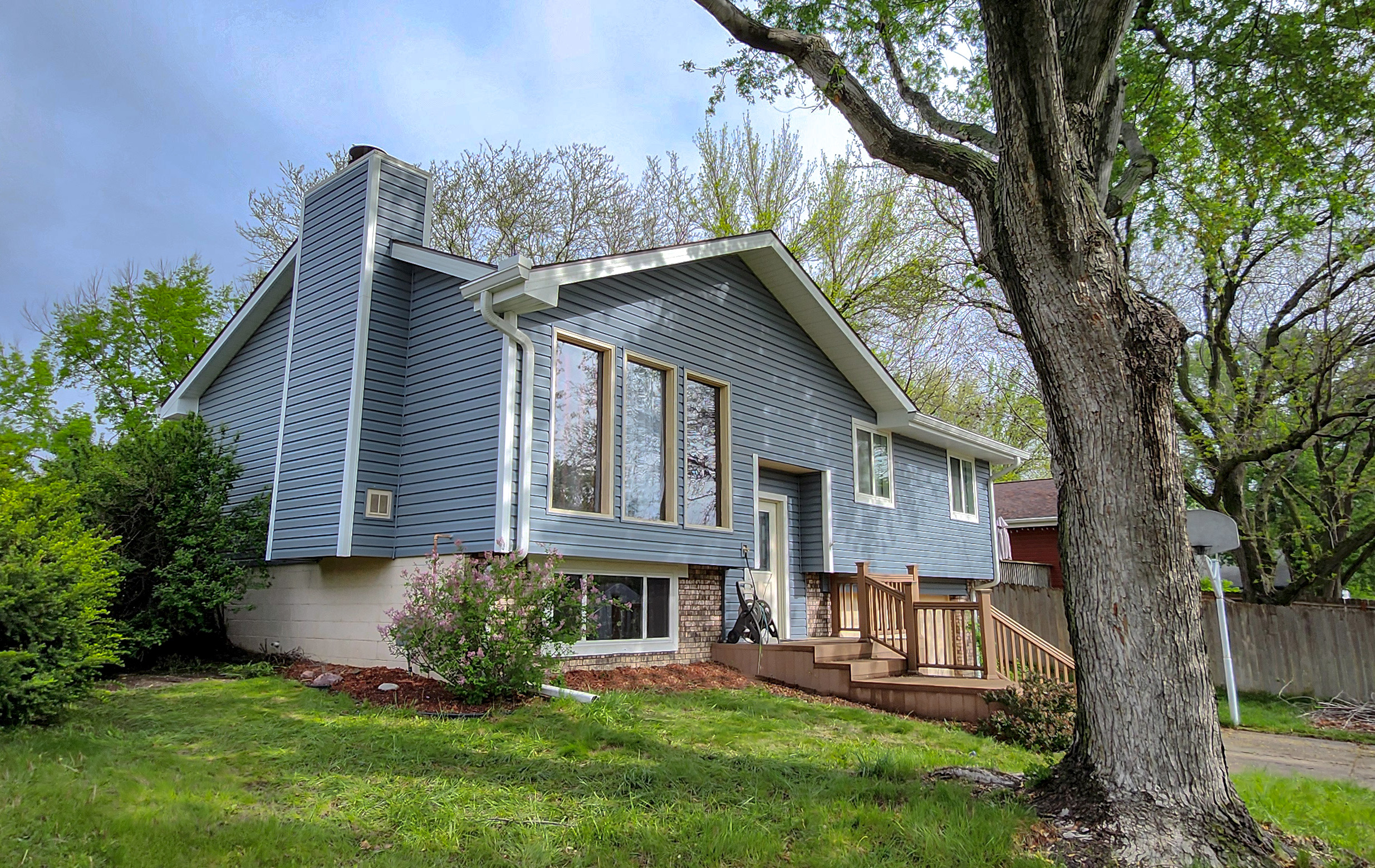 Front view of a completed siding project by Roof Rite. The home features new blue vinyl siding with white trim, enhancing curb appeal while offering durable weather protection.